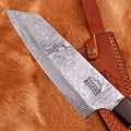 Damascus knife with a brown leather sheath on a wooden surface
