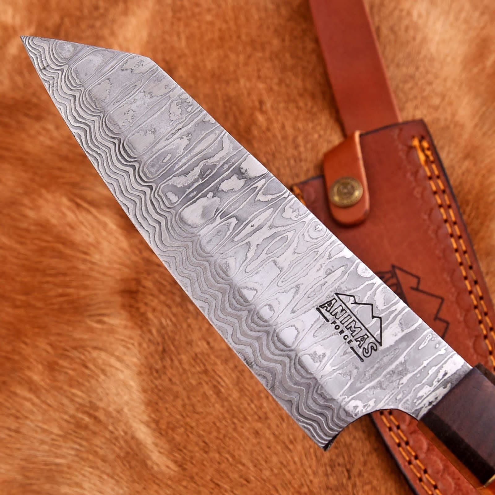 Damascus knife with a brown leather sheath on a wooden surface