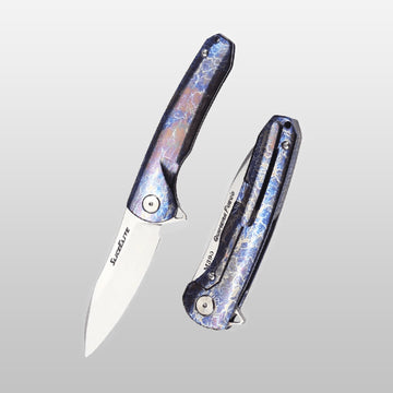 Quimera Fuego EDC Folding knife with iridescent handle on a light gray background