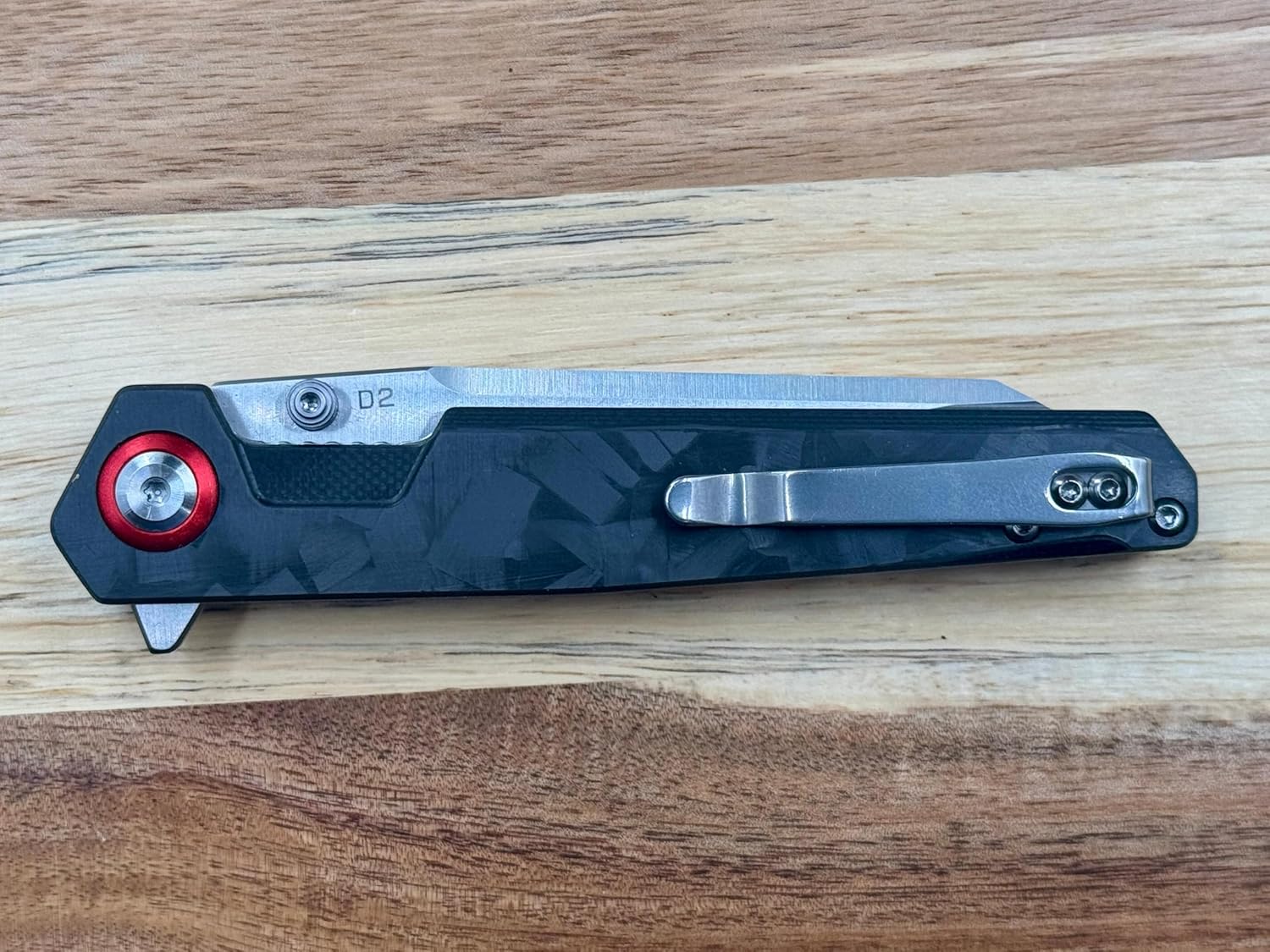 A folding knife with D2 steel blade and carbon fiber handle features liner lock design and comes in an elegant gift box for collectors and everyday carry