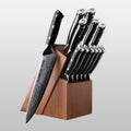 Set of knives with black handles in a wooden block on a light gray background